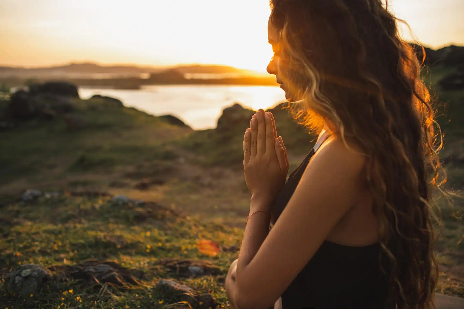Woman praying alone at sunrise