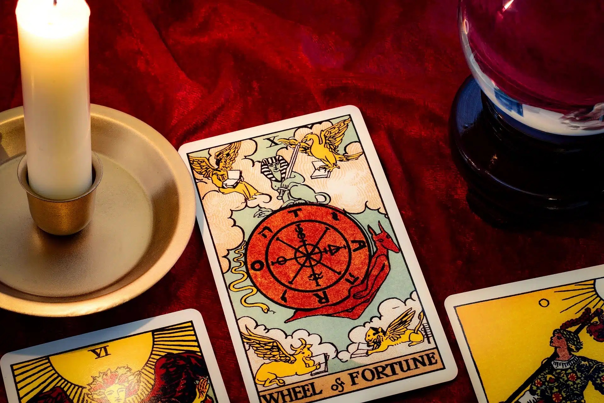 Wheel of fortune card and crystal ball under candle light. Cartomancy is fortune telling using cards, while scrying and clairvoyance is future reading using orbs, both are branches of astrology