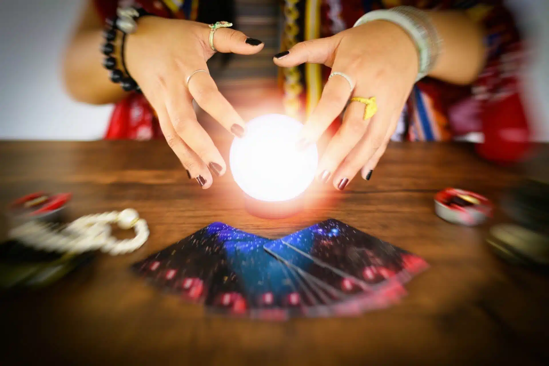Psychic readings and clairvoyance concept - Crystal ball fortune teller hands and Tarot cards reading